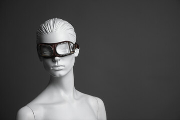 Pilot concept. Female mannequin in aviation goggles on gray background with copy space.