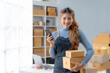 Happy Asian businesswoman starting sme holding smartphone. Small Online Business Owner, SME Work...