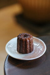 Canele in ceramic plate on wood chair - stock photo stock photo
