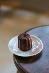Canele in ceramic plate on wood chair - stock photo stock photo
