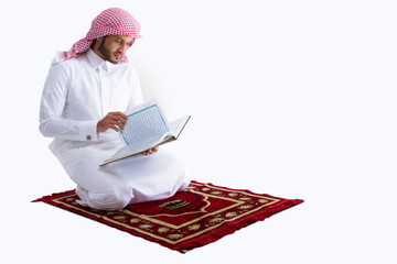 Saudi young man holding and reading Quraan