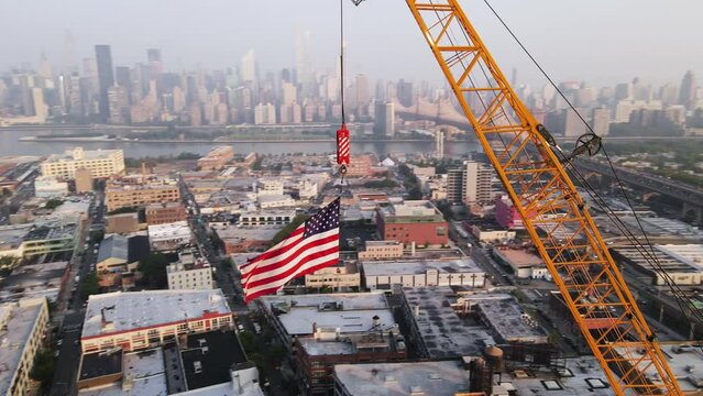 Aerial view of an Amerian Flag flying high above New York City at sunrise