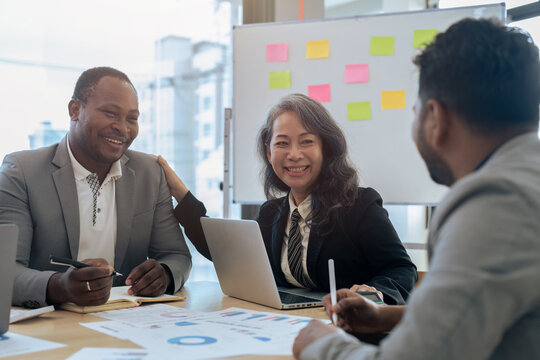 Mature Older Businesswoman Negotiating Growth Business Plan With Diverse Executive Managers At Boardroom