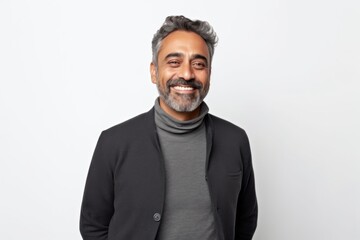 Medium shot portrait of an Indian man in his 40s against a white background wearing a chic cardigan