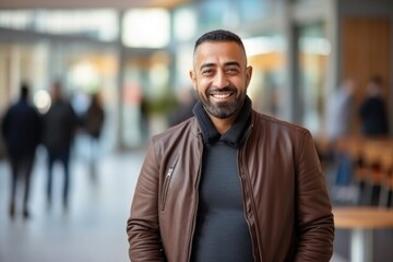 Fototapeta premium Medium shot portrait of an Indian man in his 40s against a minimalist or empty room background wearing hijab