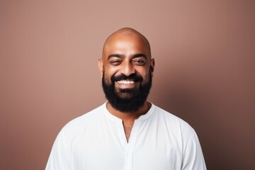 Obraz premium Medium shot portrait of an Indian man in his 40s against a minimalist or empty room background wearing hijab