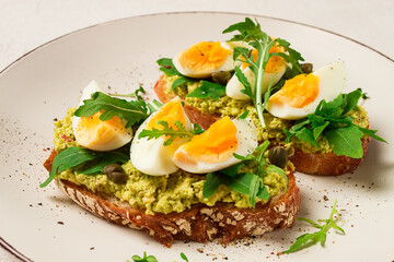 sandwich with mashed avocado, boiled egg, and arugula, on bread , homemade, breakfast,