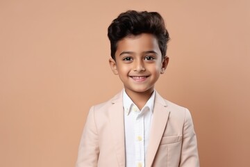 Medium shot portrait of an Indian child male against a pastel or soft colors background wearing a...