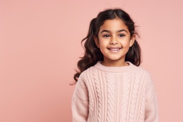 Fototapeta premium Portrait of a cute little girl smiling at camera isolated on a pink background