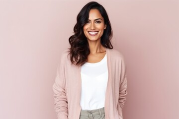 Obraz premium Portrait of beautiful woman smiling and looking at camera over pink background