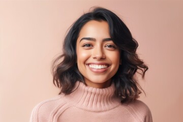 Fototapeta premium Portrait of a smiling young asian woman looking at camera isolated over beige background