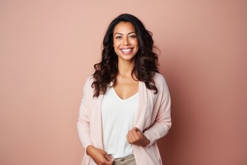 Obraz premium Portrait of a smiling young woman standing isolated over beige background