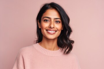 Fototapeta premium Portrait of a beautiful young woman smiling at camera isolated over pink background