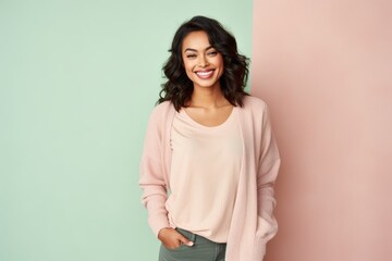 Fototapeta premium happy african american woman in sweater and pants on pink and blue background