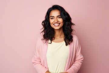 Obraz premium smiling african american woman in pink sweater over pink background