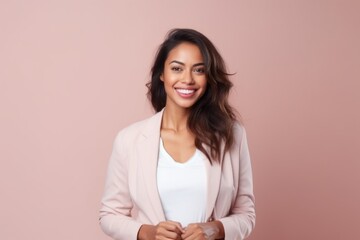 Fototapeta premium Portrait of a beautiful young woman smiling at camera on a pink background