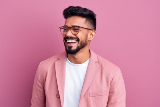 Portrait of a smiling indian man wearing eyeglasses against pink background