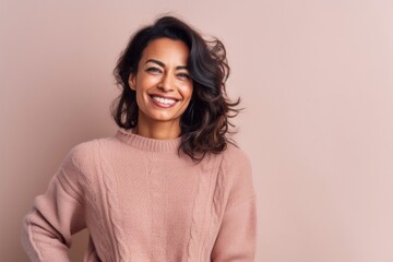 Portrait of a beautiful young woman in a pink sweater on a beige background