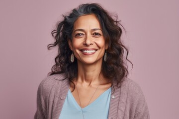 Fototapeta premium Portrait of a beautiful woman with long curly hair smiling at the camera