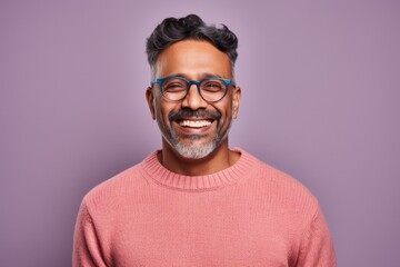 Fototapeta premium Portrait of a handsome Indian man in eyeglasses against purple background