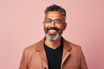 Handsome Indian man with beard and mustache wearing coat and glasses