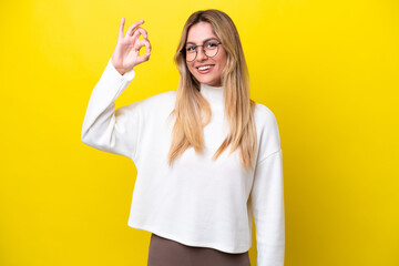 Young Uruguayan woman isolated on yellow background showing ok sign with fingers