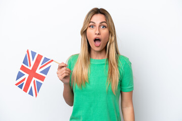 Young Uruguayan woman holding an United Kingdom flag isolated on white background with surprise and shocked facial expression - obrazy, fototapety, plakaty