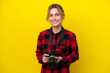 Uruguayan photographer woman isolated on yellow background keeping the arms crossed in frontal position