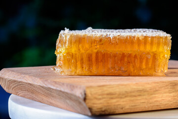 Close up on delicious organic honeycomb on a wooden cutting board.