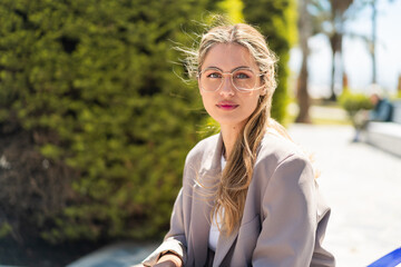Pretty blonde Uruguayan woman with glasses at outdoors . Portrait