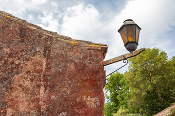 Ancient Red Adobe Brick Wall and Antique Lantern in Colonia del Sacramento UNESCO site, Uruguay 