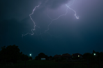 Lightning discharge high in the sky during a severe nighttime thunderstorm