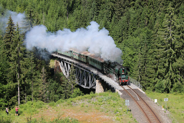 A steam locomotive driving through the Krkonoše hills