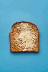 Top view of isolated toasted bread with butter on blue background. Breakfast concept.