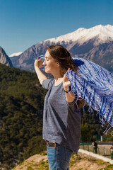 Fototapeta na wymiar a beautiful girl on the background of the mountains is covered with a blanket
