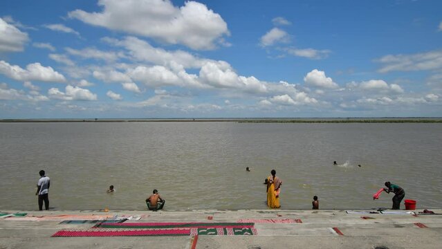 The timelapse video shows people going about their daily routines on the banks of the Jamuna River in Bangladesh, as clouds move overhead and children swim in the water.