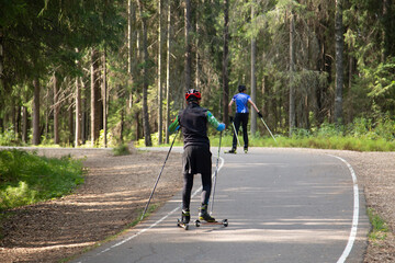A man on a roller ski rides in the park.Cross country skilling.