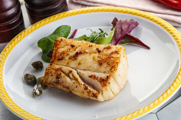 Roasted cod fish steak with salad