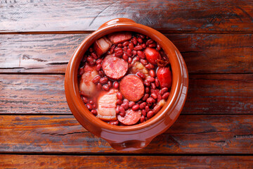brazilian feijoada in ceramic bowl isolated on rustic wooden background. Copy space