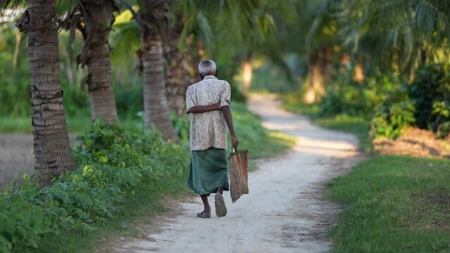 An aged person is walking on a village path. Rural beauty of Bangladesh.