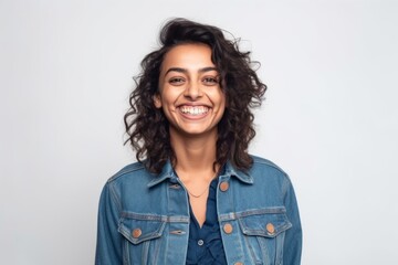 Fototapeta premium Medium shot portrait of an Indian woman in her 30s wearing a denim jacket against a white background