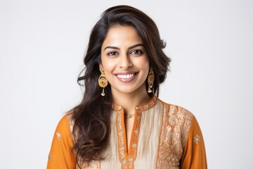 Lifestyle portrait of an Indian woman in her 30s wearing salwar kameez against a white background - obrazy, fototapety, plakaty