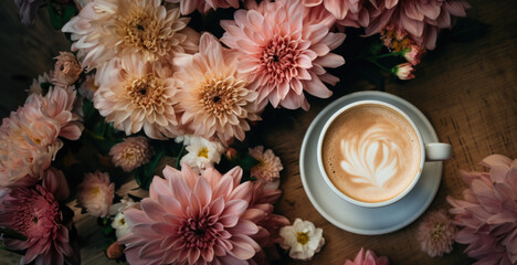 Spring morning concept. Flat-lay of cup of coffee surrounded with white ranunculus flowers over light pink pastel background, top view,