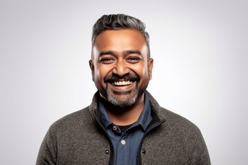 Obraz premium Lifestyle portrait of an Indian man in his 40s wearing hijab against a white background