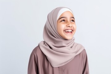 Medium shot portrait of an Indian child female wearing hijab in a minimalist background