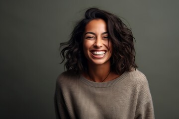 Fototapeta premium Lifestyle portrait of an Indian woman in her 30s in a minimalist background