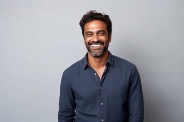 Medium shot portrait of an Indian man in his 30s in a minimalist background