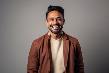 Medium shot portrait of an Indian man in his 30s in a minimalist background