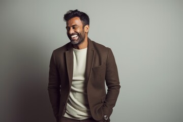 Lifestyle portrait of an Indian man in his 30s in a minimalist background
