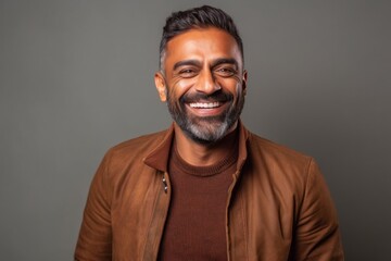 Obraz premium Lifestyle portrait of an Indian man in his 30s in a minimalist background